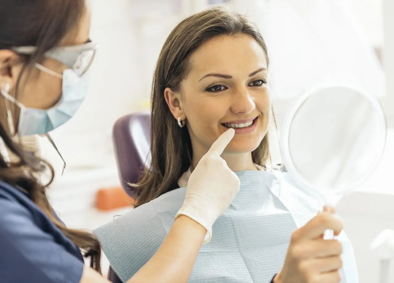 Dentist showing patient her smile in mirror.